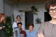woman facing camera with blurry group of people behind her