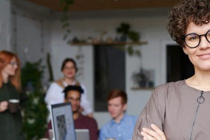 woman facing camera with blurry group of people behind her
