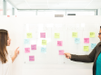 women at white board with sticky notes