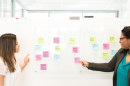 women at white board with sticky notes