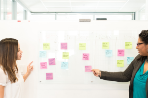 women at white board with sticky notes