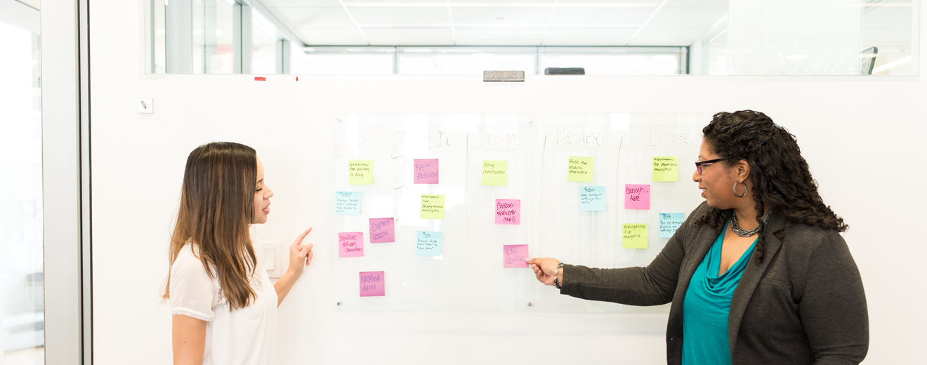 women at white board with sticky notes