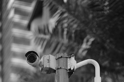 Black and white photo of security cameras on a pole in downtown Qatar.