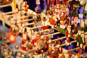 A vibrant collection of Christmas snow globes and hanging ornaments at a festive market stall.