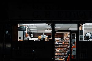 Exterior view of a convenience store at night, showcasing its well-lit interior.